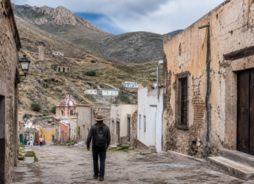 Calle empedrada de Real de Catorce con antiguos edificios mineros y montañas del altiplano